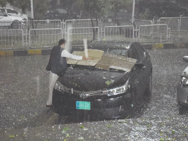 as hail hammers down a man scrambles to protect his car mirroring scenes from the last tempest that left citizens in islamabad counting heavy losses photo online as hail hammers down a man scrambles to protect his car mirroring scenes from the last tempest that left citizens in islamabad counting heavy losses photo online