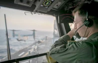 a naval officer aboard uss tripoli lha 7 oversees flight operations from the control tower as the amphibious assault ship sails in the arabian sea us warships and aircraft deployed to the middle east are enforcing the naval blockade against iran photo centcom x
