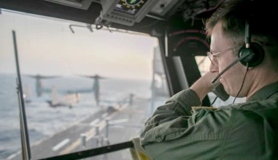 a naval officer aboard uss tripoli lha 7 oversees flight operations from the control tower as the amphibious assault ship sails in the arabian sea us warships and aircraft deployed to the middle east are enforcing the naval blockade against iran photo centcom x