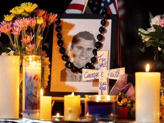 candles and flowers are seen near a portrait of right wing activist charlie kirk at a makeshift memorial during a candlelight vigil at memorial park in provo utah on september 12 2025 after he was shot during a public event at utah valley university photo afp