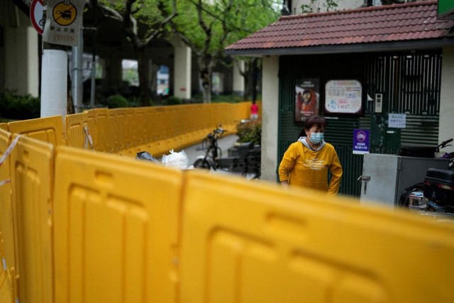 a resident is seen behind barriers sealing off an area under lockdown amid the coronavirus disease covid 19 pandemic in shanghai china april 14 2022 reuters aly song a resident is seen behind barriers sealing off an area under lockdown amid the coronavirus disease covid 19 pandemic in shanghai china april 14 2022 reuters aly song