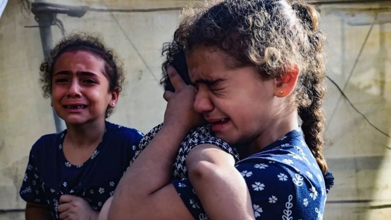 a smoke plume rises during israeli children react during the funeral of the faojo family killed in israeli bombing on rafah in the southern gaza strip on 11 november 2023 photo afp