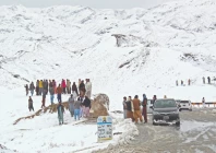 people gather along a snow covered area near the pak afghan border in chaman photo afp