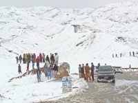 people gather along a snow covered area near the pak afghan border in chaman photo afp