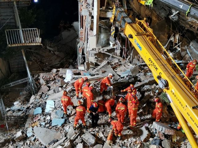 rescue workers work next to a crane at the site where a hotel building collapsed in suzhou jiangsu province china july 12 2021 cnsphoto via reuters rescue workers work next to a crane at the site where a hotel building collapsed in suzhou jiangsu province china july 12 2021 cnsphoto via reuters