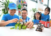 a volunteer 2nd l instructs a child how to assemble a robot in qingdao east china s shandong province july 24 2026 photo xinhua