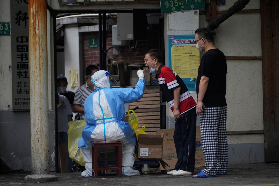 a medical worker collects a swab sample from a man on a street during lockdown amid the coronavirus disease covid 19 outbreak in shanghai china may 30 2022 photo reuters