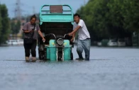 residents push a vehicle as they wade through a flooded street following heavy rainfall brought by remnants of typhoon dolphin in xuchang henan province china on august 13 2026 photo reuters file