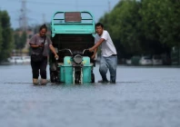 residents push a vehicle as they wade through a flooded street following heavy rainfall brought by remnants of typhoon dolphin in xuchang henan province china on august 13 2026 photo reuters file