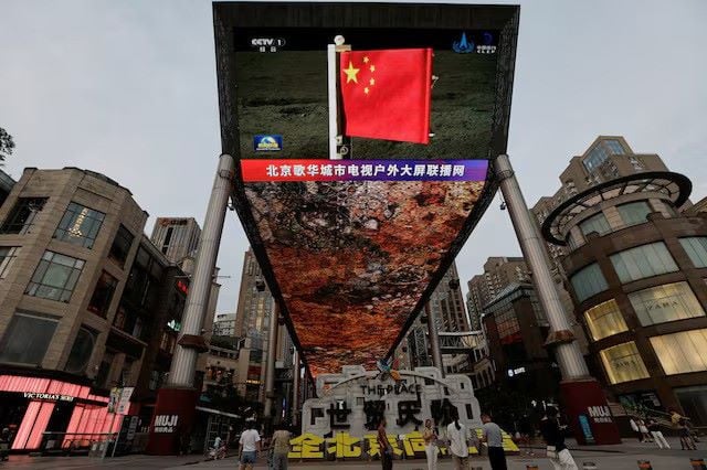 A large screen shows news footage of a Chinese national flag carried by Chang'e-6 probe's lander on the far side of the moon, in Beijing, China June 4, 2024. PHOTO:REUTERS