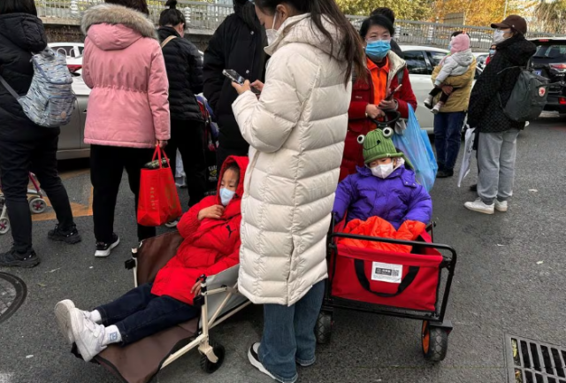 people stand next to children sitting in camping carts as they wait for their rides outside a children s hospital in beijing china november 27 2023 reuters tingshu wang file photo acquire licensing rights people stand next to children sitting in camping carts as they wait for their rides outside a children s hospital in beijing china november 27 2023 reuters tingshu wang file photo acquire licensing rights