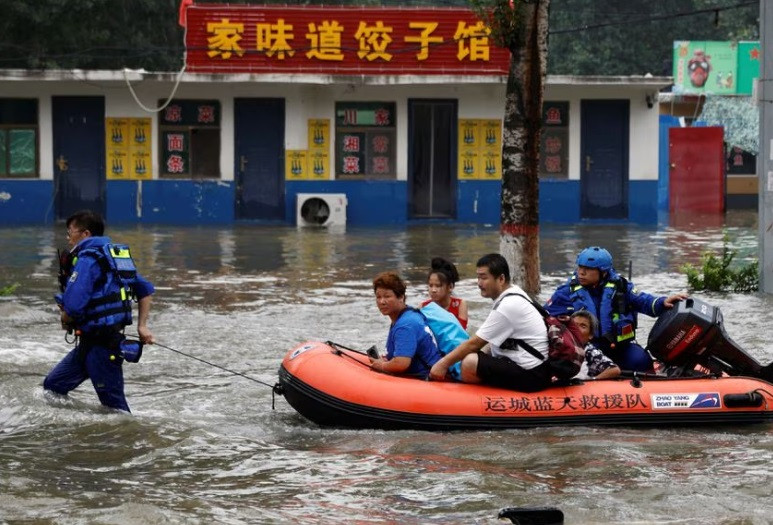rescue workers from shanxi province evacuate people through floodwaters with a boat after the rains and floods brought by remnants of typhoon doksuri in zhuozhou hebei province china august 3 2023 reuters tingshu wang