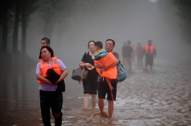 residents wade through floodwaters following heavy rainfall in zhuozhou hebei province china august 1 2023 cnsphoto via reuters residents wade through floodwaters following heavy rainfall in zhuozhou hebei province china august 1 2023 cnsphoto via reuters