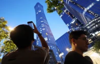 a man points a mobile phone at citic tower also known as china zun where damage is visible on a high floor of the exterior in beijing china june 26 2026 photo reuters