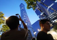 a man points a mobile phone at citic tower also known as china zun where damage is visible on a high floor of the exterior in beijing china june 26 2026 photo reuters
