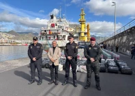this undated handout photo released on january 12 2026 by spanish national police shows spanish police posing in front of some of the nearly 10 tons of cocaine seized on a cargo ship that was sailing across the atlantic between brazil and spain at the port of santa cruz de tenerife in spain s canary islands photo afp spanish national police