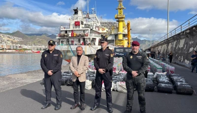 this undated handout photo released on january 12 2026 by spanish national police shows spanish police posing in front of some of the nearly 10 tons of cocaine seized on a cargo ship that was sailing across the atlantic between brazil and spain at the port of santa cruz de tenerife in spain s canary islands photo afp spanish national police