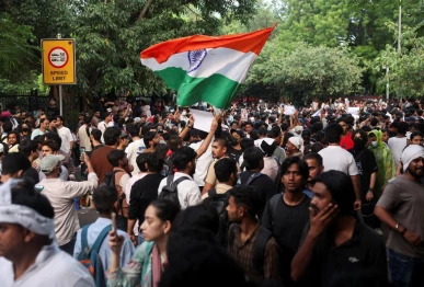 a supporter of india s cockroach janata party cjp holds an indian national flag at the ongoing protest site a few days after thousands of protesters marched towards parliament demanding the resignation of education minister dharmendra pradhan over national eligibility cum entrance test neet examination paper leaks at jantar mantar in new delhi india july 23 2026 photo reuters