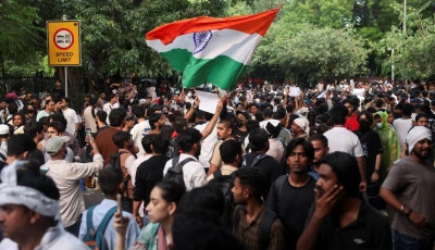 a supporter of india s cockroach janata party cjp holds an indian national flag at the ongoing protest site a few days after thousands of protesters marched towards parliament demanding the resignation of education minister dharmendra pradhan over national eligibility cum entrance test neet examination paper leaks at jantar mantar in new delhi india july 23 2026 photo reuters