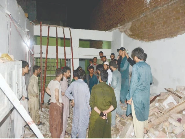 a group of men is standing amidst the rubble of the seminary roof assessing the damage after its tragic collapse claimed the lives of two children photo app a group of men is standing amidst the rubble of the seminary roof assessing the damage after its tragic collapse claimed the lives of two children photo app