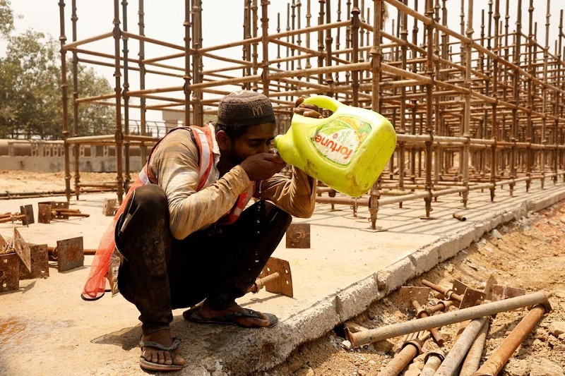 a construction worker drinks water from a container a construction site during a hot summer day in new delhi india may 22 2024 photo reuters