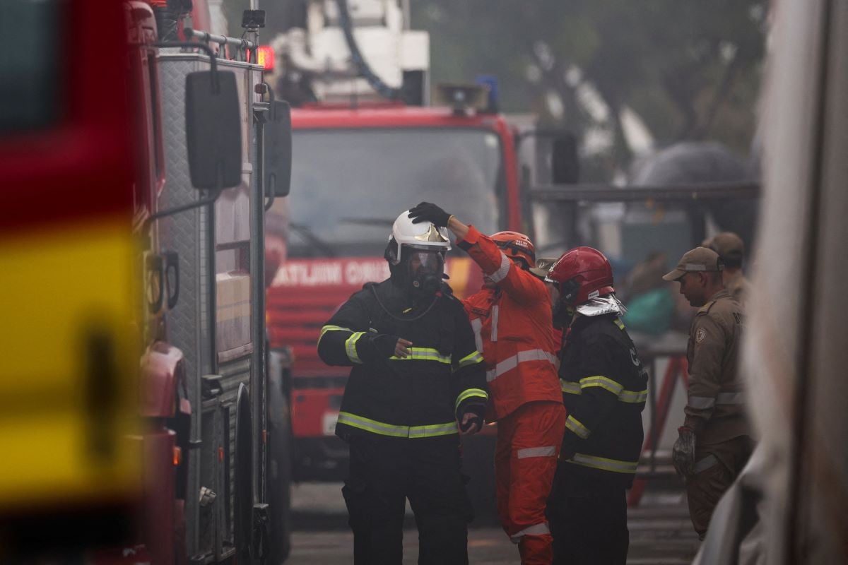 A firefighter is assisted with the helmet following a fire alert during the UN Climate Change Conference (COP30), in Belem, Brazil, November 20, 2025. REUTERS