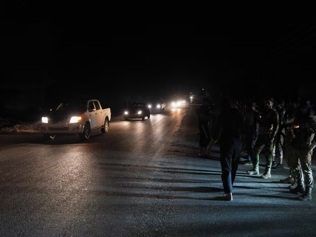 Members of Syrian security forces stand on the side of a road in Sweida countryside, as vehicles transporting other Syrian security forces make their way out of the predominantly druze city of Sweida, Syria, July 16, 2025. REUTERS/Karam al-Masri