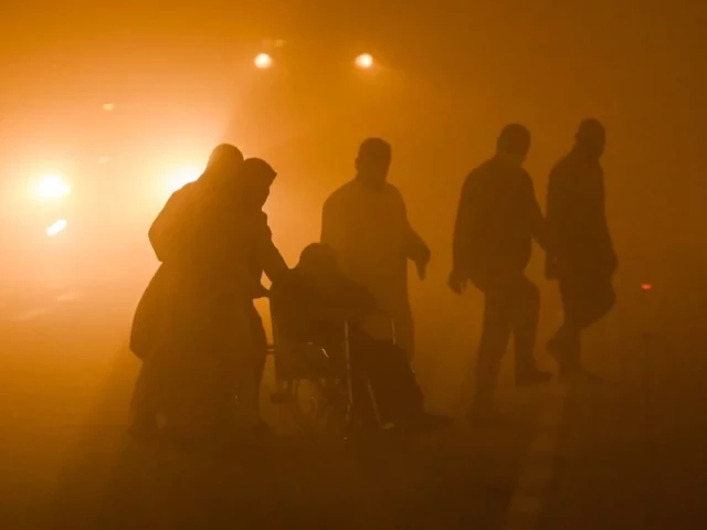 a wheelchair bound person is assisted by others to cross to a traffic island in the middle of a road in low visibility conditions amidst a massive dust storm in iraq s southern city of basra on april 14 2025 photo afp a wheelchair bound person is assisted by others to cross to a traffic island in the middle of a road in low visibility conditions amidst a massive dust storm in iraq s southern city of basra on april 14 2025 photo afp