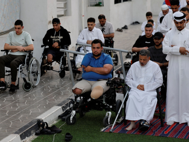 A Palestinian, Ibrahim Qadeeh, who was injured in the Israel-Hamas conflict, attends Eid al-Adha prayers along with others on the first day of the Muslim holiday of Eid al-Adha, at Al Thumama Complex, in Doha, Qatar, June 6, 2025.