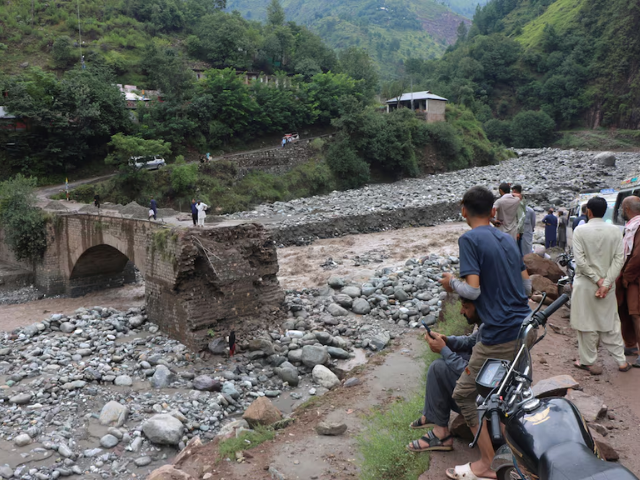 Residents gather at the site of a damaged bridge following a storm that caused heavy rains and flooding on the outskirts of Muzaffarabad, the capital of Kashmir, August 15, 2025. REUTER