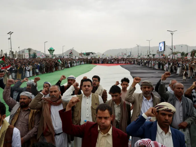 Protesters, mainly Houthi supporters, shout slogans as they stand around a Palestinian flag during a rally to show solidarity with Palestinians in Gaza, in Sanaa, Yemen, on July 4, 2025 [Khaled Abdullah/Reuters]