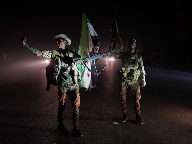 Members of Syrian security forces stand on a road in Sweida countryside, as vehicles transporting other Syrian security forces make their way out of the predominantly druze city of Sweida, Syria, July 16, 2025. REUTERS/Karam al-Masri