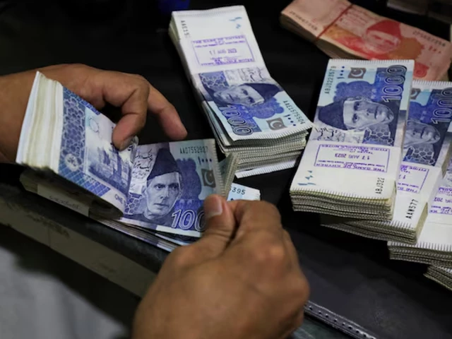 an employee counts pakistani rupee notes at a bank in peshawar on august 22 2023 photo reuters