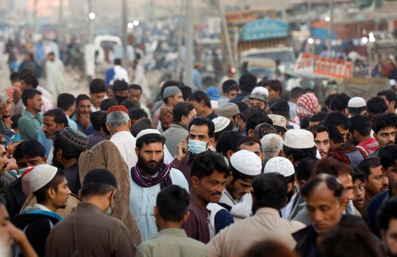 A man wearing a protective mask walks through a crowd of people along a makeshift market as the third of the deadly Covid-19 pandemic grips nation. PHOTO: REUTERS/File