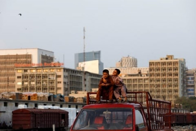 boys sit on the roof of a vehicle as they play with the financial district s buildings in the background as the outbreak of the coronavirus disease covid 19 continues in karachi pakistan photo reuters boys sit on the roof of a vehicle as they play with the financial district s buildings in the background as the outbreak of the coronavirus disease covid 19 continues in karachi pakistan photo reuters