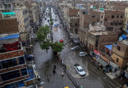 commuters make their way through a flooded street during heavy monsoon rains in hyderabad on july 14 2025 photo afp