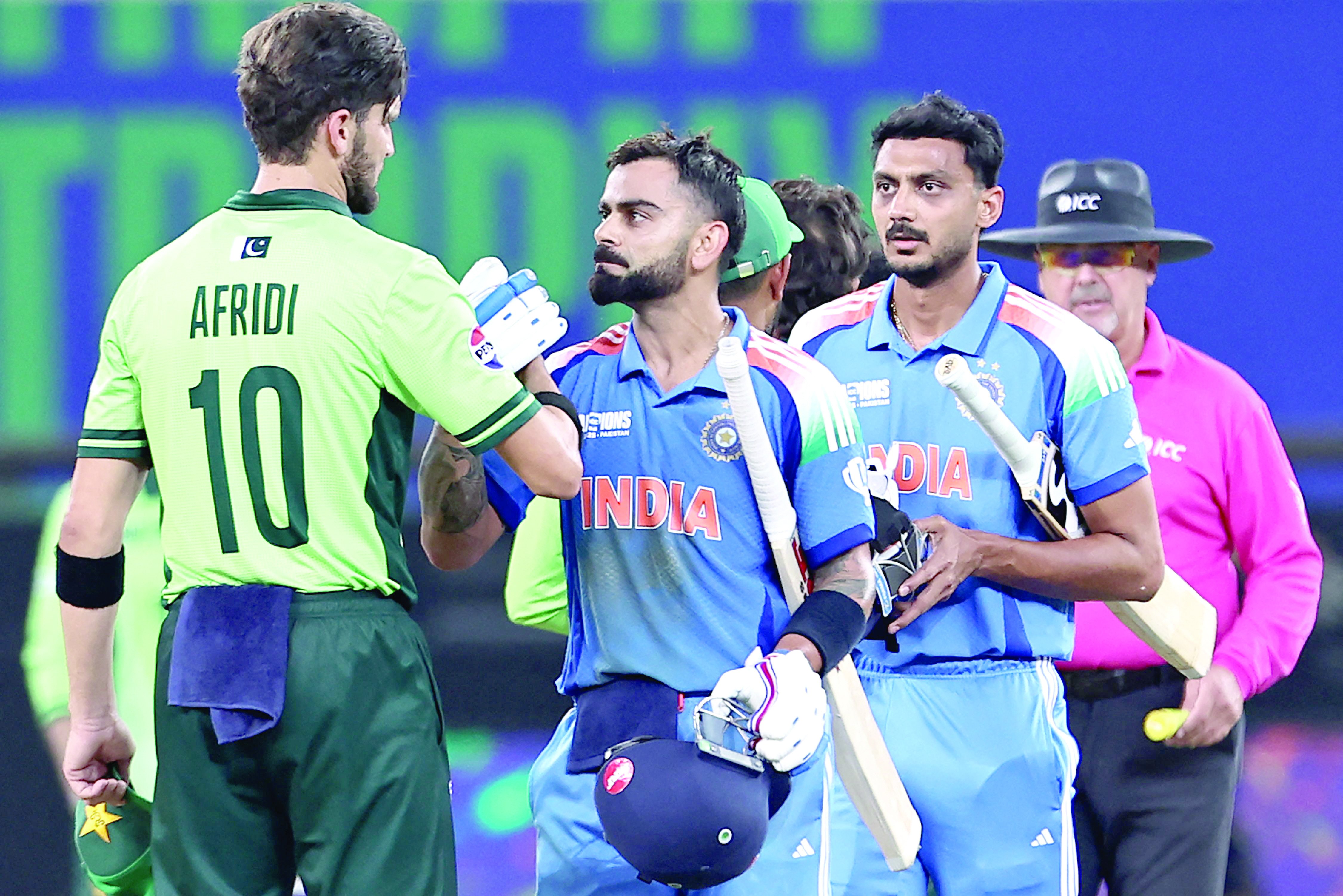 pakistani pacer shaheen shah afridi congratulates indian batsman virat kohli as india s axar patel looks on on their team s victory in the icc champions trophy one day international cricket match at the dubai international stadium photo afp