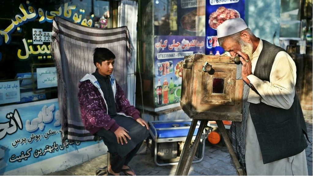 haji mirzaman takes a portrait of a boy with his homemade wooden box camera known as a kamra e faoree afp