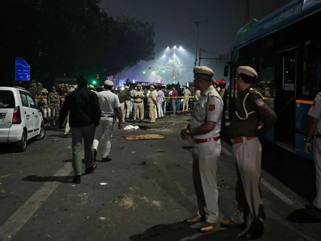 security personnel gather at the blast site after an explosion near the red fort in the old quarters of delhi on november 10 2025 indian fire officers on november 10 reported injuries after fire engulfed several vehicles close to the capital s landmark red fort but the cause of the blaze was not confirmed photo afp