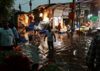 a man wades through a waterlogged street in a wholesale market after rain in new delhi india may 2 2025 reuters