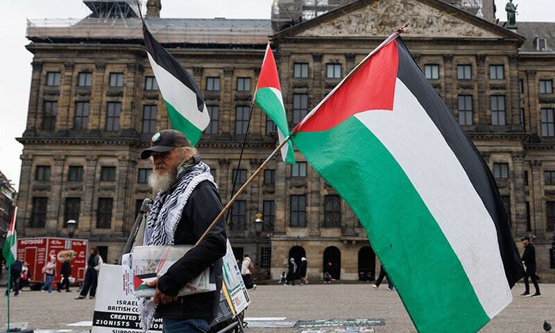 a man carries palestinian flags in dam square in front of the royal palace of amsterdam on november 15 afp