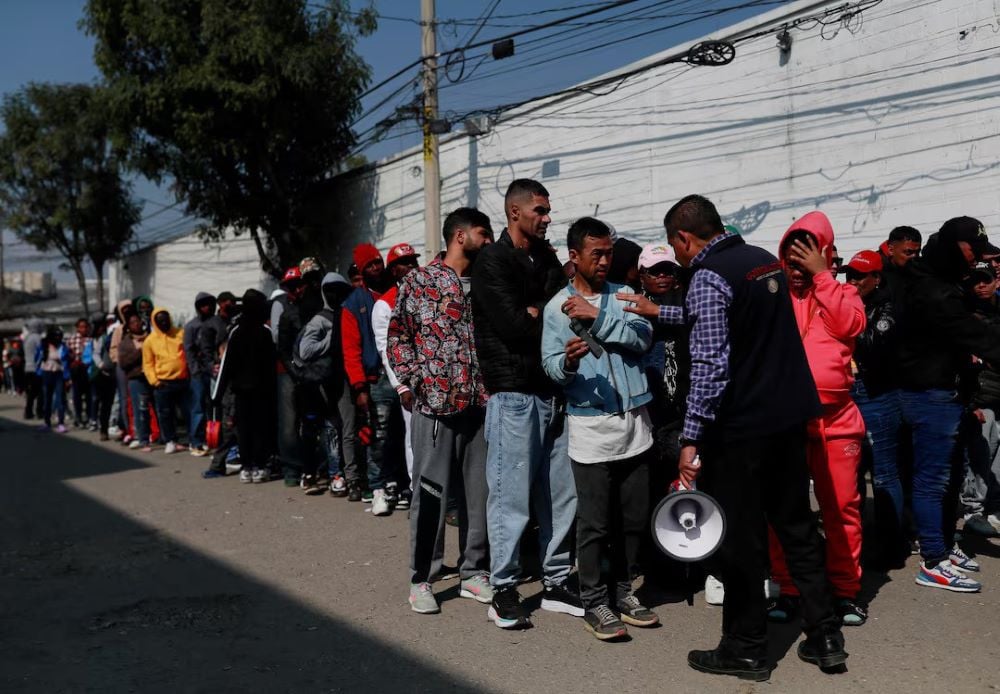 an official of the commission for refugee assistance comar talks with migrants outside the mexican commission for refugee assistance comar as they wait in line to regularise their migratory situation in the country in mexico city mexico january 24 2025 photo reuters