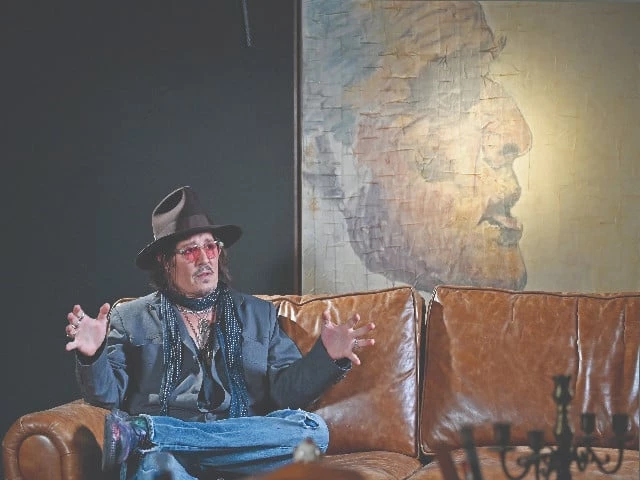 actor johnny depp speaks in front of one of his paintings during an interview after a media preview of his art exhibition in tokyo photo afp