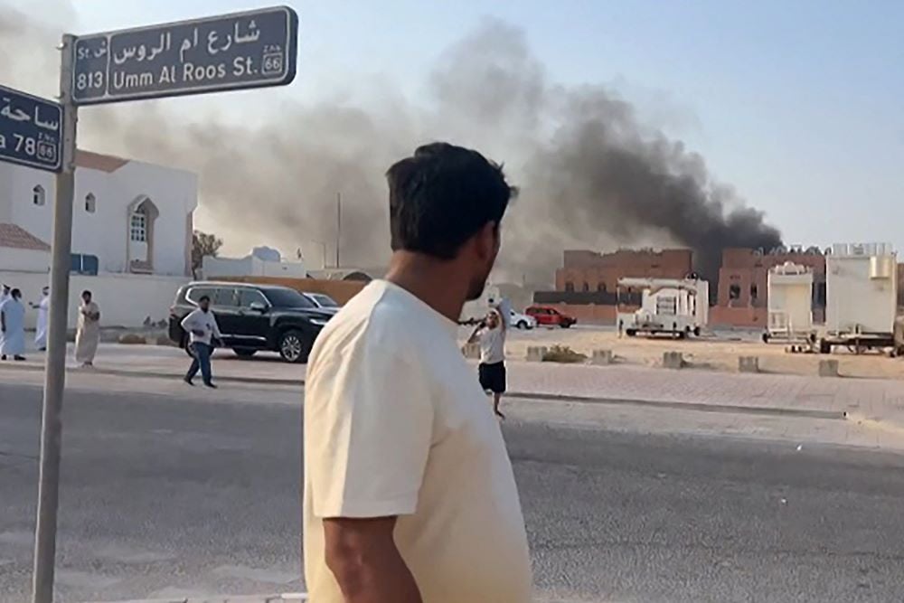 This frame grab taken from an AFPTV footage shows a man looking at smoke billowing after explosions in Doha's capital Qatar on September 9, 2025. PHOTO: AFP
