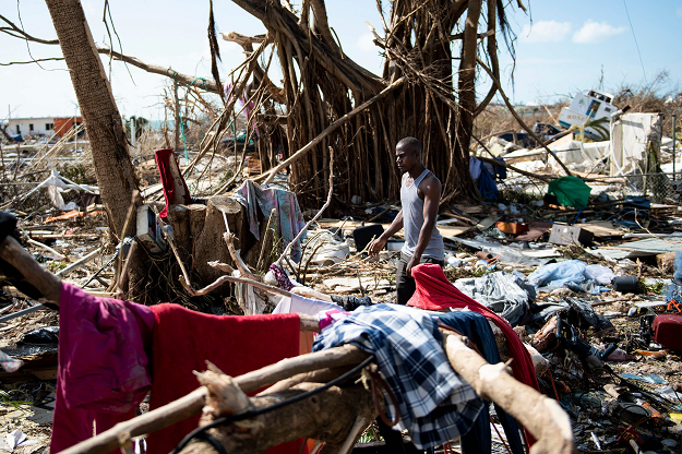 A man walks past damages caused by Hurricane Dorian on September 5, 2019, in Marsh Harbour, Great Abaco Island in the Bahamas. PHOTO: AFP