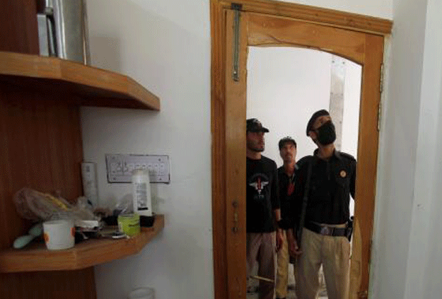 Police look at the destroyed door to the dorm room of Mashal Khan, accused of blasphemy, who was killed by a mob at Abdul Wali Khan University in Mardan, Pakistan April 14, 2017. PHOTO: REUTERS