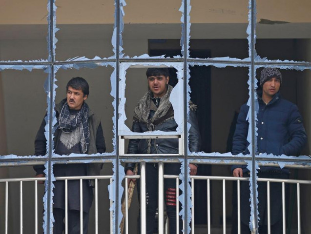 afghan men look out from a damaged window of their building at the site of a blast in kabul afghanistan december 20 2020 reuters
