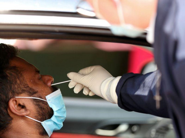 a health worker tests a motorist at a drive trough covid 19 testing site amid a nationwide coronavirus disease covid 19 lockdown at a dis chem pharmacy in midrand south africa january 18 2021 reuters