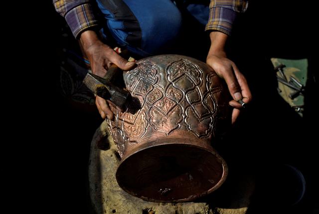 file photo a kashmiri artisan engraves designs on a traditional copper samovar inside his workshop in downtown srinagar march 1 2021 picture taken march 1 2021 reuters sanna irshad mattoo file photo reuters