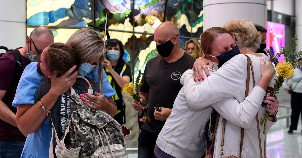 travellers arriving on the first quarantine free international flights are embraced by family at sydney international airport november 1 2021 reuters